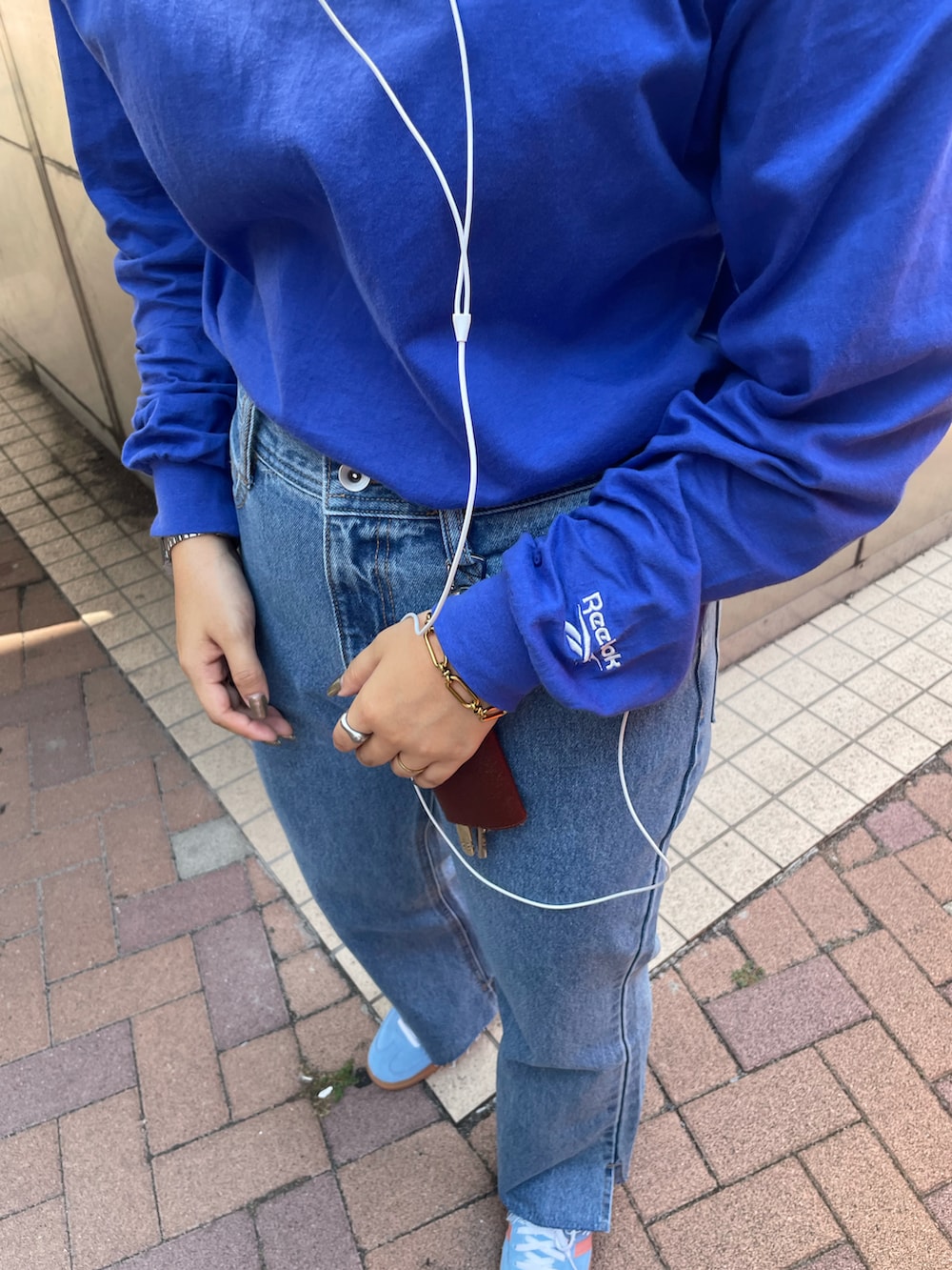 ブルー系のTシャツ/カットソー、ブルー系のデニムパンツ、ブルー系のスニーカーを着用したレディースの秋コーディネートの3枚目の写真