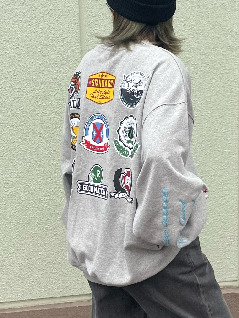 ブラック系のデニムパンツ、グレー系のスウェット、ブラウン系のスニーカーを着用したレディースの秋コーディネートの3枚目の写真