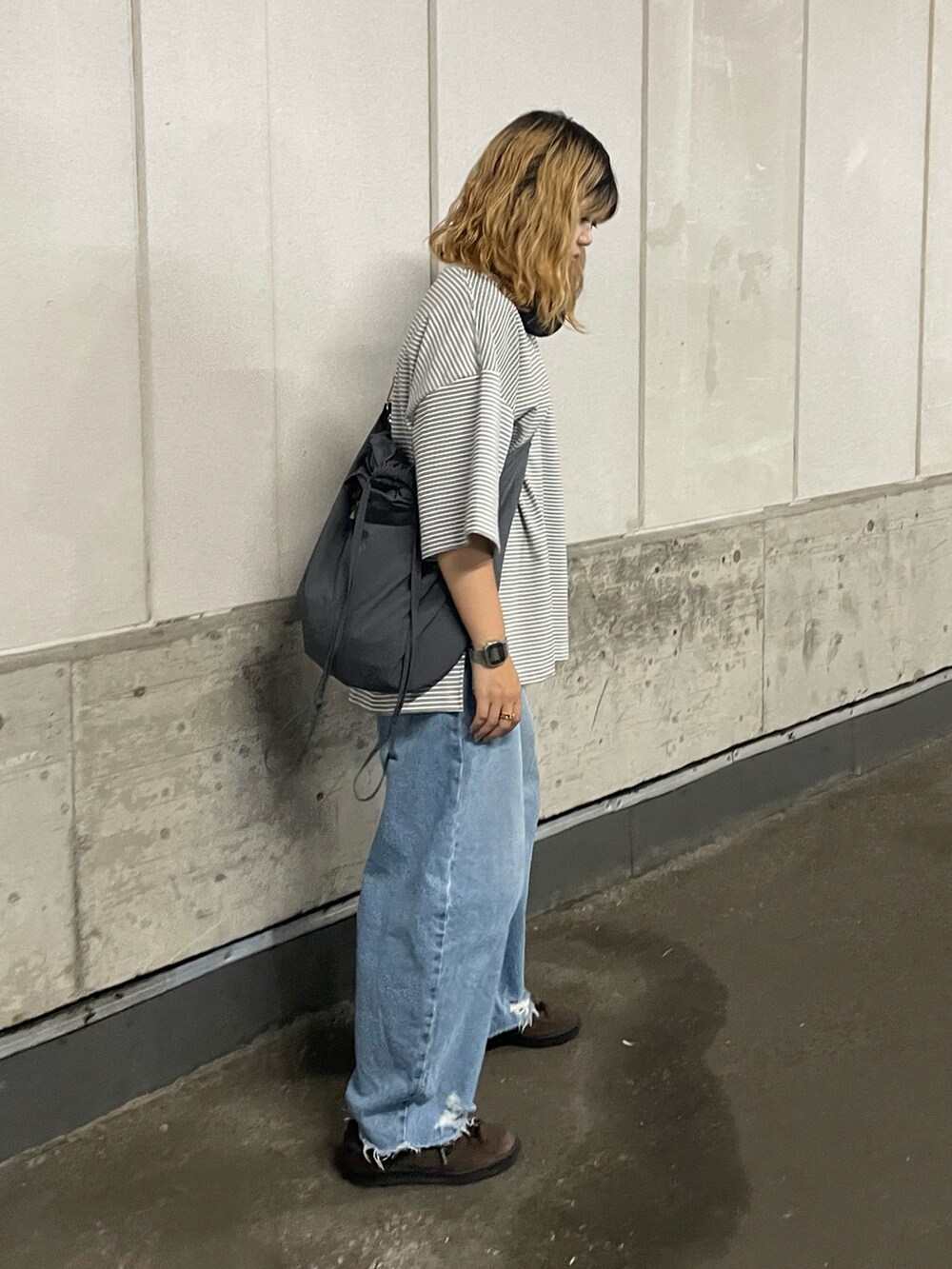 ブルー系のデニムパンツ、ブラウン系のスニーカー、ホワイト系のTシャツ/カットソーを着用したレディースの夏コーディネートの2枚目の写真