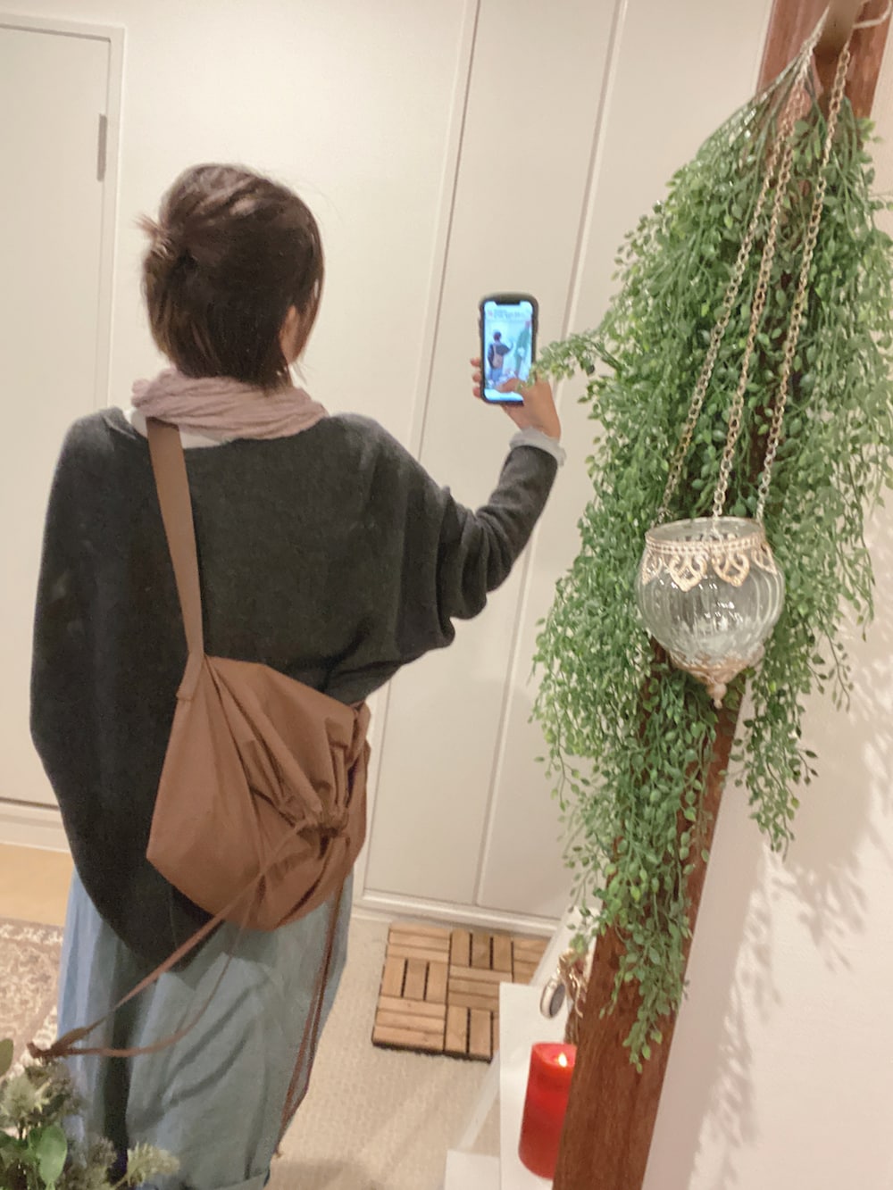 ブラウン系のショルダーバッグ、ブルー系のパンツ、グレー系のカーディガン/ボレロを着用したレディースの秋コーディネートの2枚目の写真