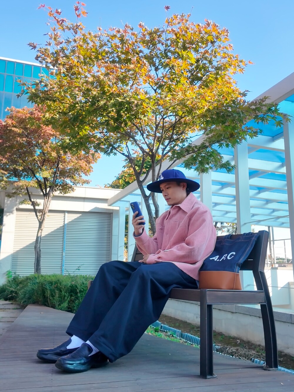 ピンク系のジャケット/アウター、ブルー系のトートバッグ、ブラック系のシューズを着用したメンズの秋コーディネートの3枚目の写真