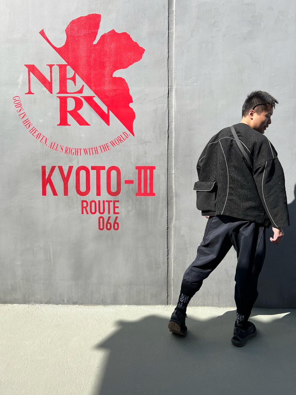 ブラック系のバッグ、ブラック系のその他アウター、ブラック系のTシャツ/カットソーを着用したメンズの夏コーディネートの3枚目の写真