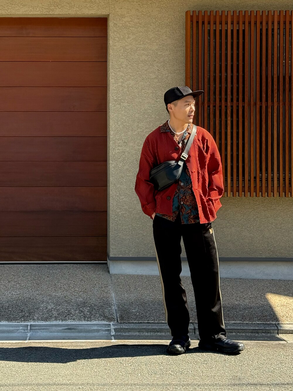 ブラック系のチノパンツ、ブラック系のサンダル、ブルー系のシャツ/ブラウスを着用したメンズの秋コーディネートの2枚目の写真