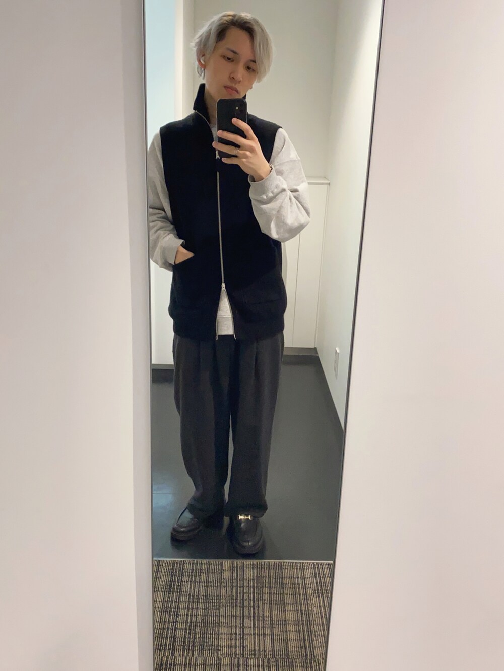 ブラック系のスラックス、ブラック系のベスト、グレー系のスウェットを着用したメンズの春コーディネートの2枚目の写真