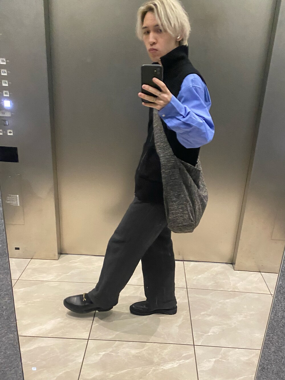 ブルー系のシャツ/ブラウス、ブラック系のベスト、ブラック系のスラックスを着用したメンズの春コーディネートの2枚目の写真