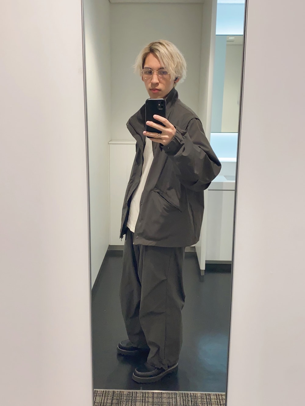 グレー系のその他パンツ、グレー系のナイロンジャケット、ブラック系のその他シューズを着用したメンズの春コーディネートの2枚目の写真