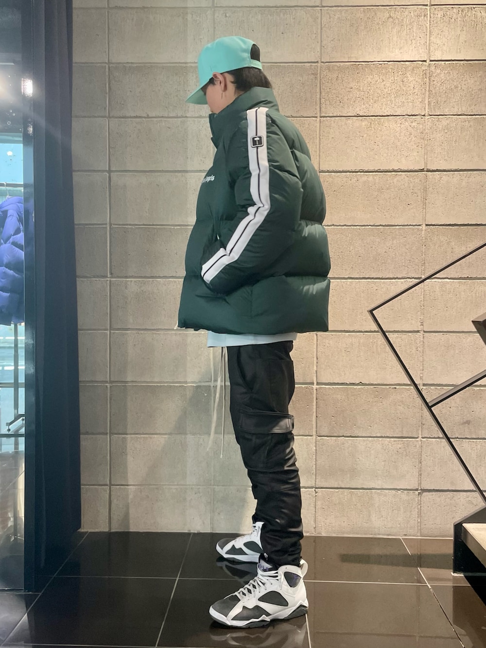 ブラック系のカーゴパンツ、グリーン系のダウンジャケット/コートを着用したメンズの冬コーディネートの2枚目の写真