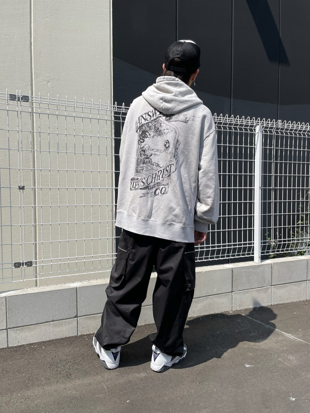 ブラック系のカーゴパンツ、ホワイト系のパーカー、ブラック系のカーゴパンツを着用したメンズの春コーディネートの4枚目の写真