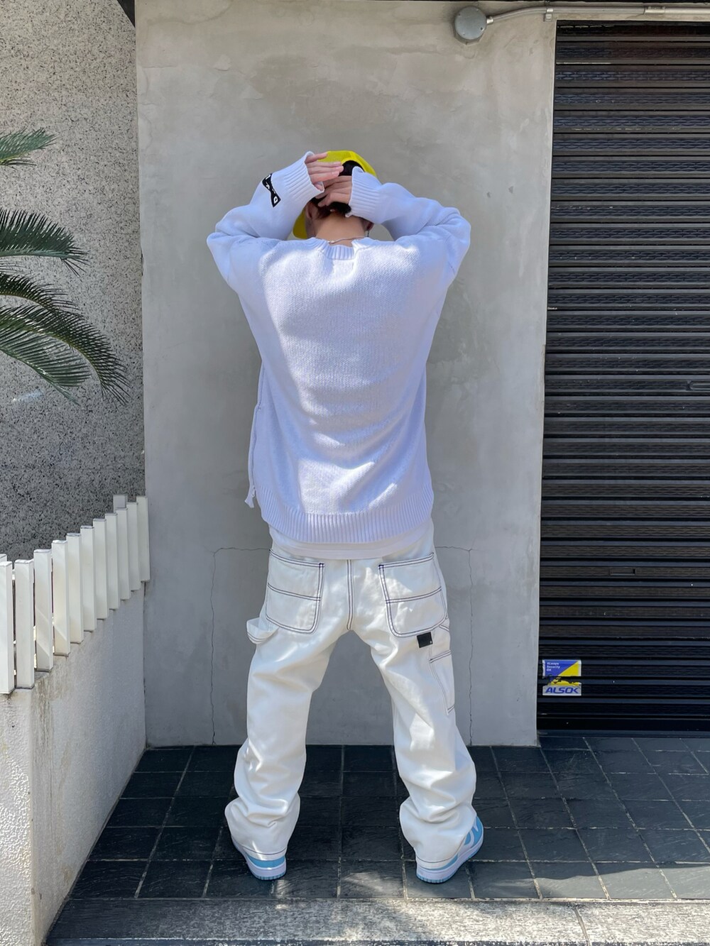 ホワイト系のニット/セーター、ホワイト系のデニムパンツ、ホワイト系のニット/セーターを着用したメンズの春コーディネートの3枚目の写真