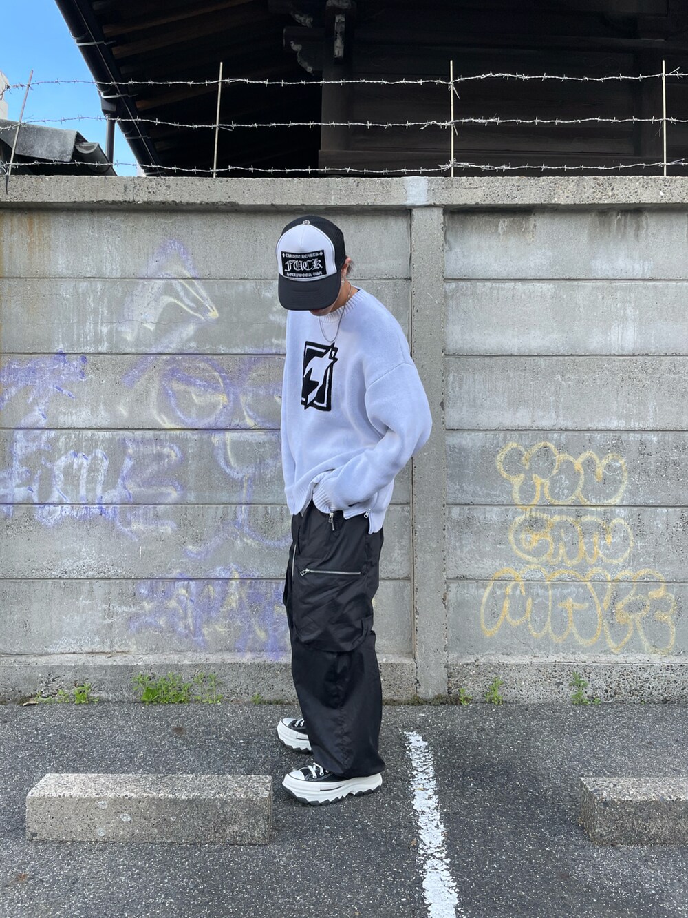 ホワイト系のニット/セーター、ブラック系のカーゴパンツ、ブラック系のカーゴパンツを着用したメンズの春コーディネートの2枚目の写真