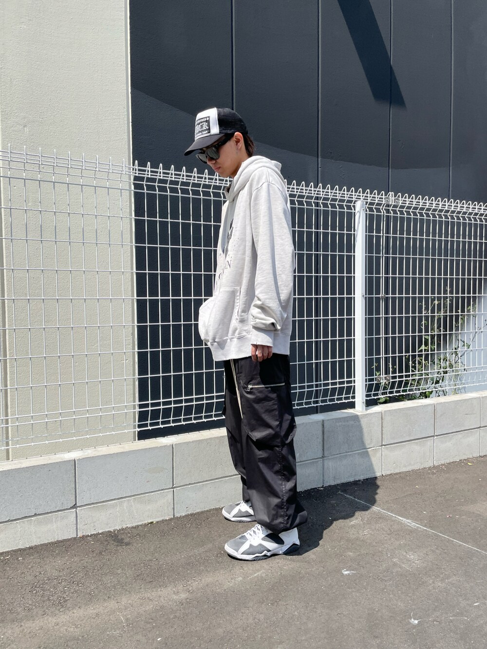 ブラック系のカーゴパンツ、ホワイト系のパーカー、ブラック系のカーゴパンツを着用したメンズの春コーディネートの3枚目の写真