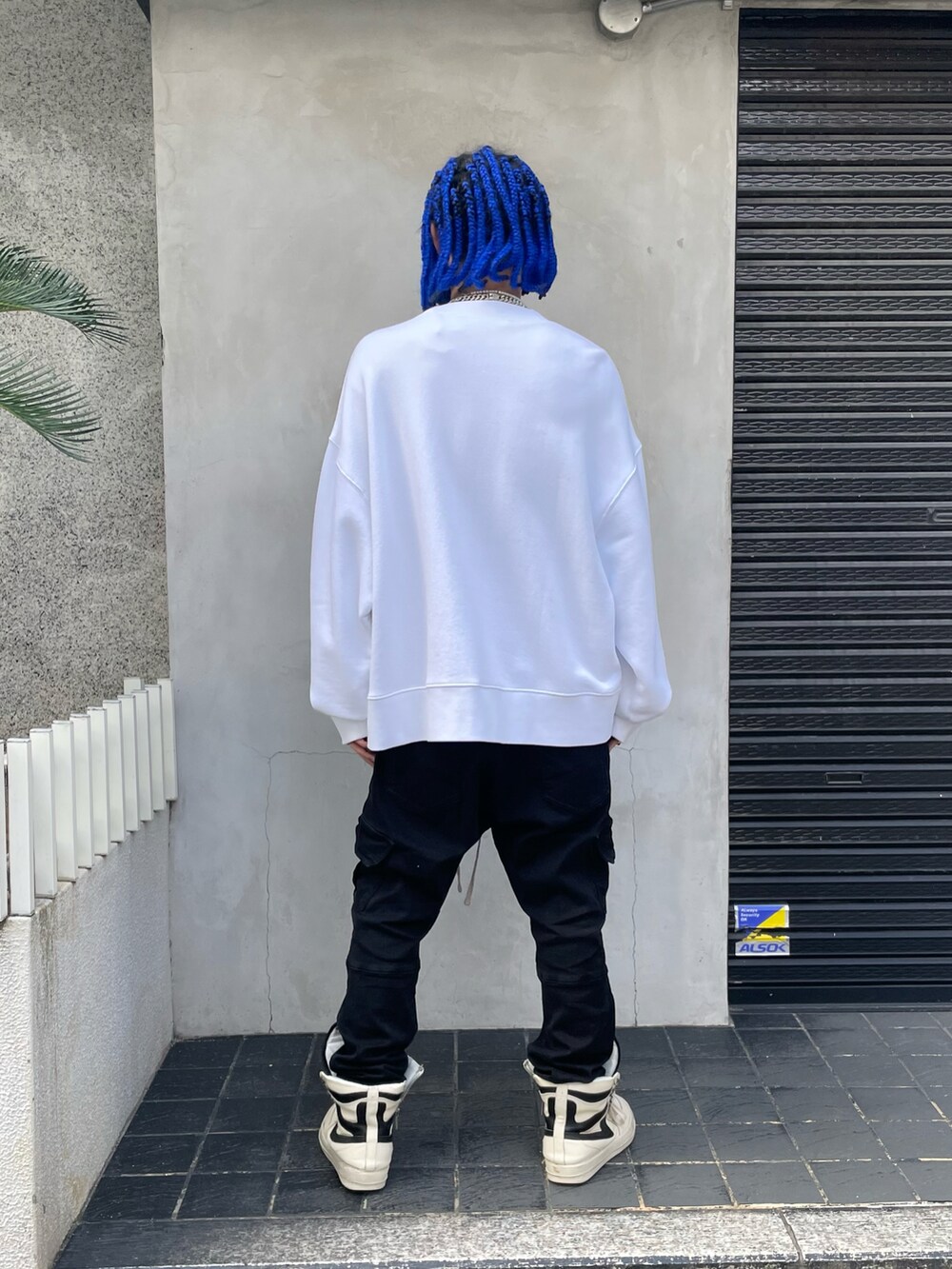 ホワイト系のスウェット、ブラック系のカーゴパンツ、ブラック系のカーゴパンツを着用したメンズの秋コーディネートの3枚目の写真