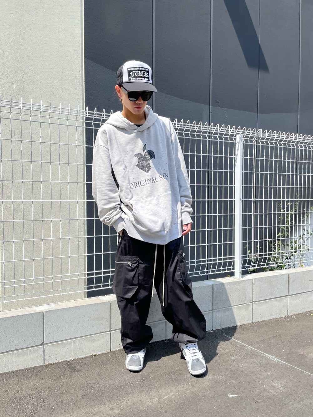 ブラック系のカーゴパンツ、ホワイト系のパーカー、ブラック系のカーゴパンツを着用したメンズの春コーディネートの2枚目の写真