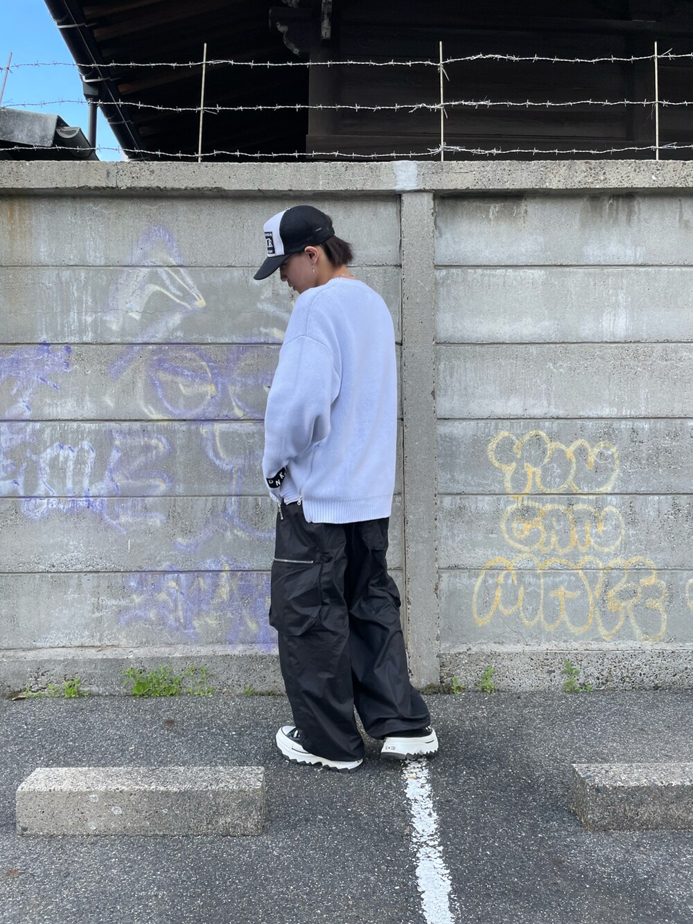 ホワイト系のニット/セーター、ブラック系のカーゴパンツ、ブラック系のカーゴパンツを着用したメンズの春コーディネートの3枚目の写真