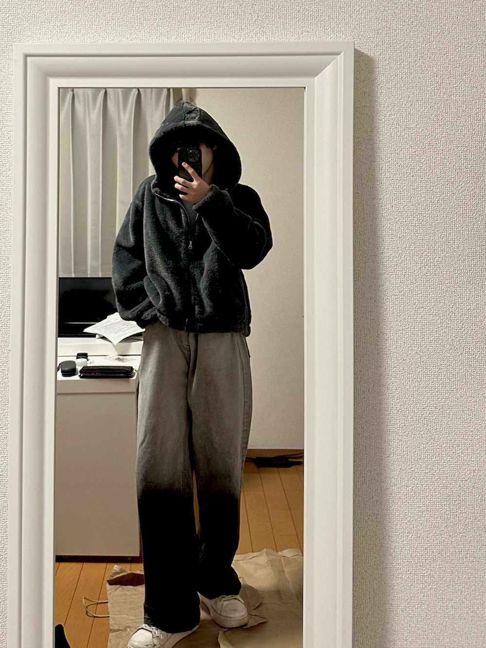ホワイト系のスニーカー、ブラック系のデニムパンツ、グレー系のパーカーを着用したメンズの秋コーディネートの3枚目の写真