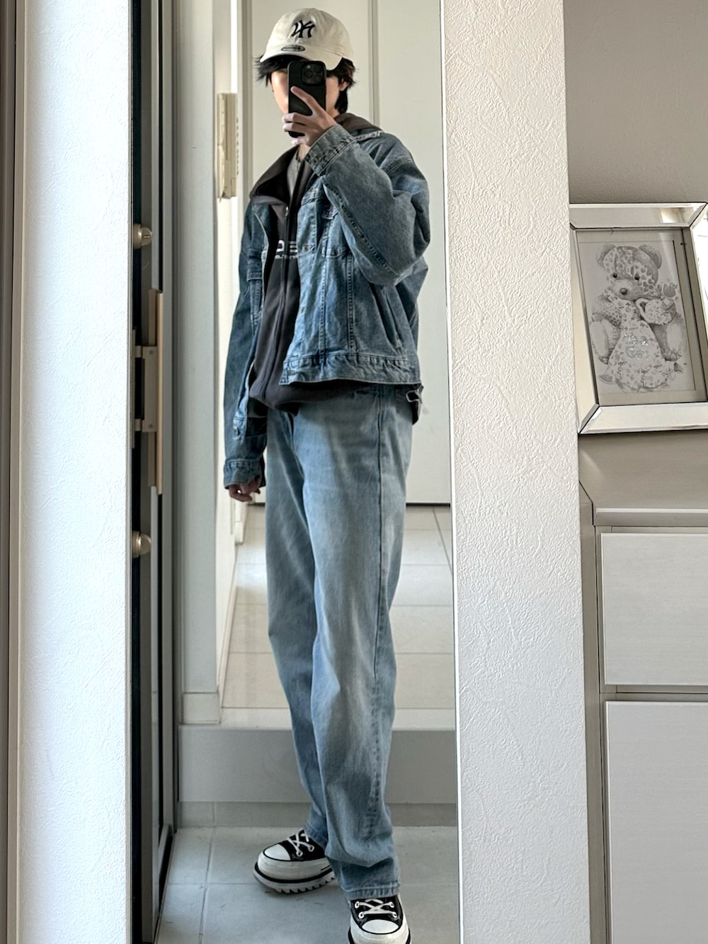 ブルー系のデニムパンツ、ブラック系のスニーカー、ブルー系のデニムジャケットを着用したメンズの冬コーディネートの3枚目の写真