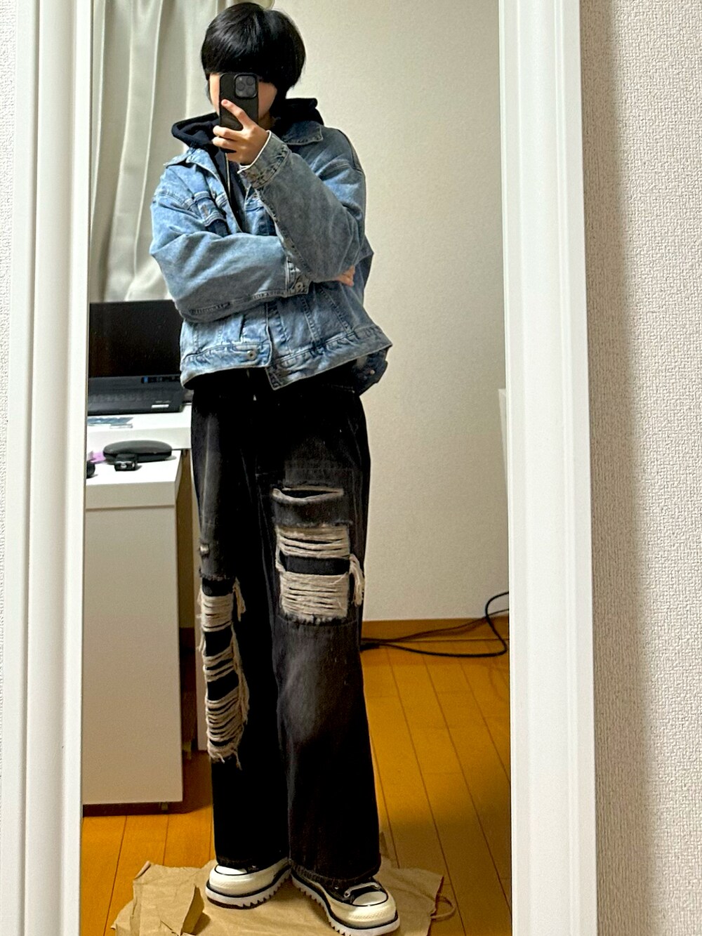 ブルー系のデニムジャケット、ブラック系のパーカー、ブラック系のデニムパンツを着用したメンズの冬コーディネートの2枚目の写真