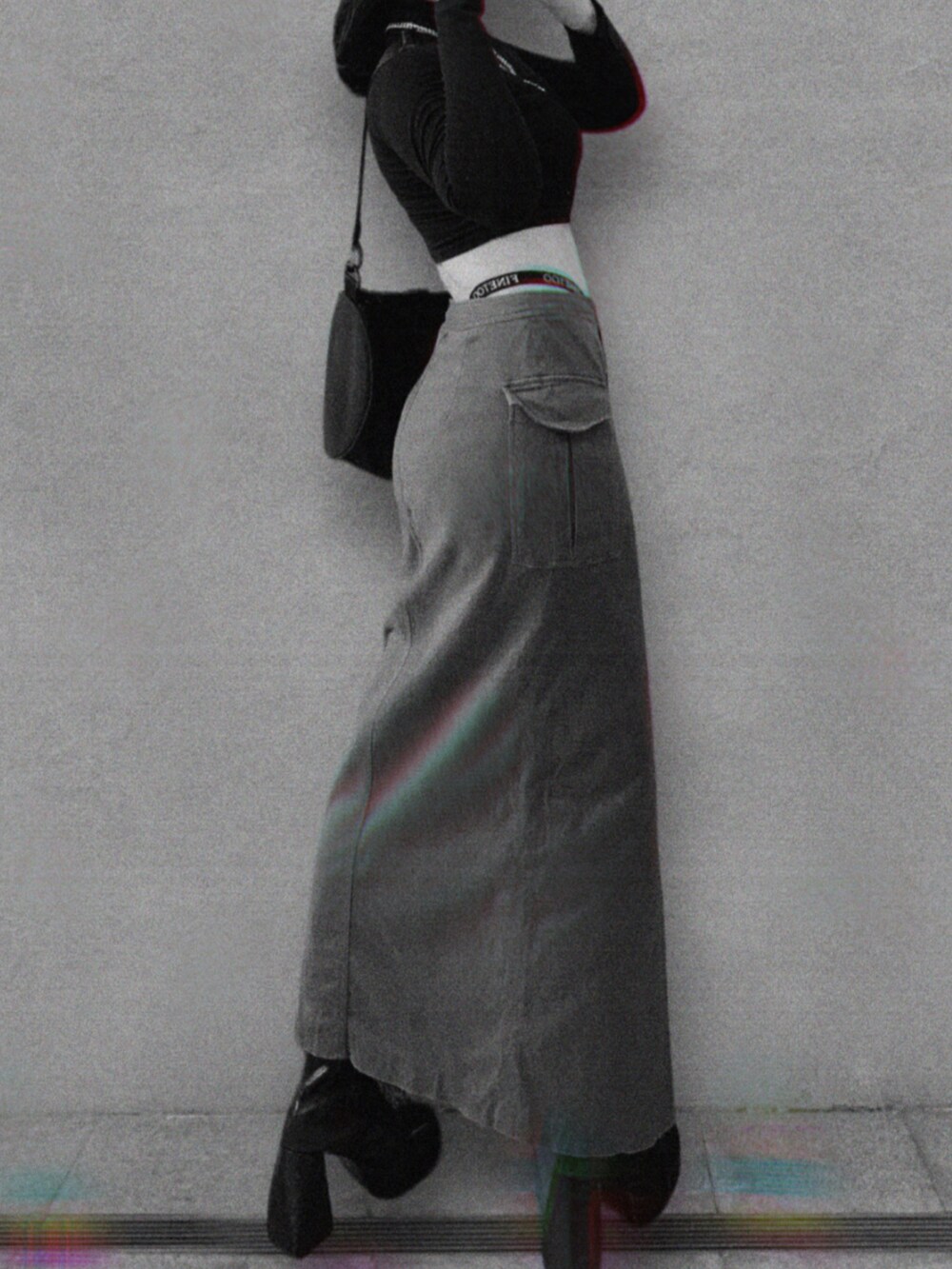 ブラック系のトップス、ブラック系のブーツを着用したレディースの春コーディネートの2枚目の写真