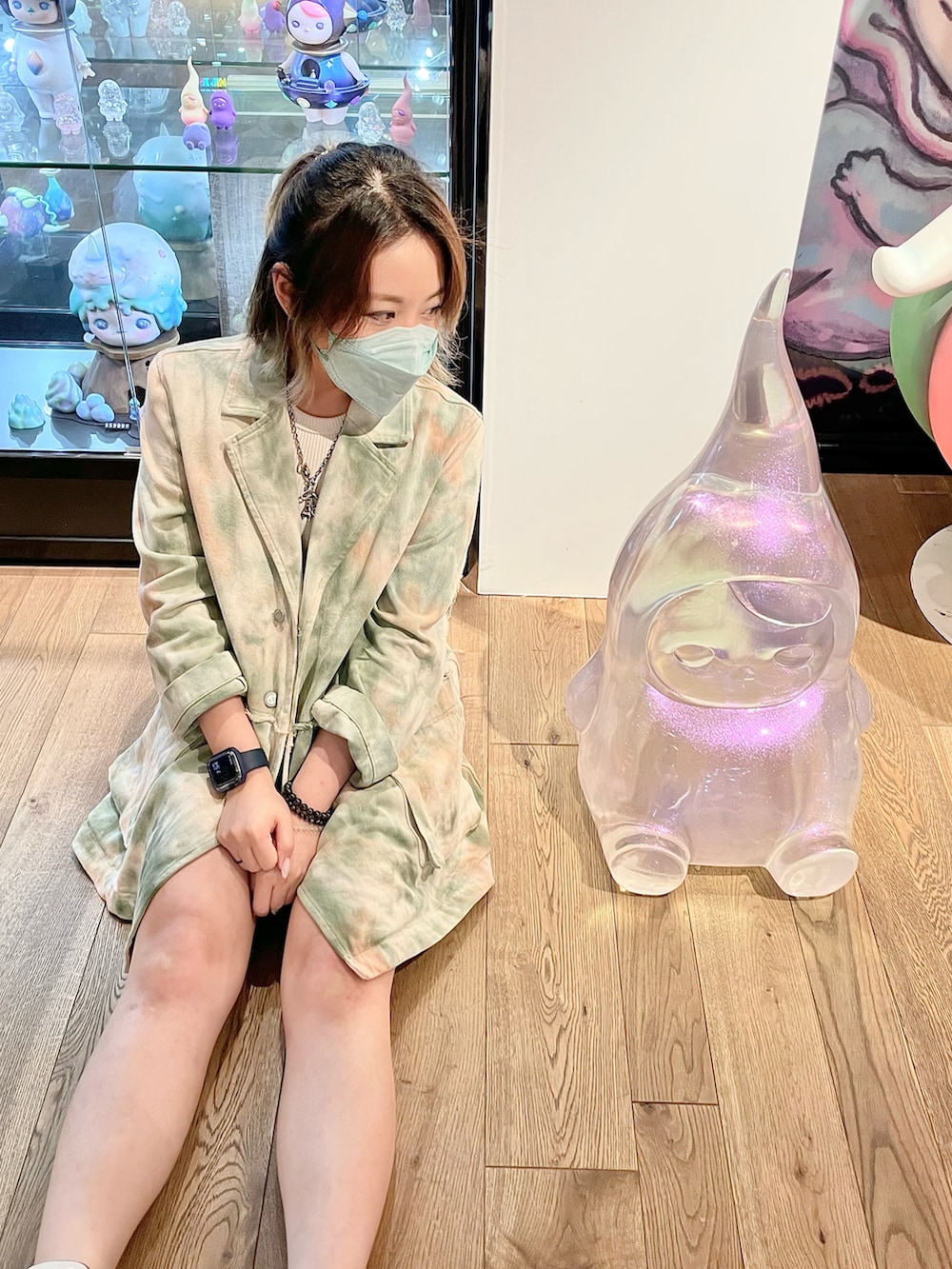 グリーン系のチェスターコート、ピンク系のスニーカー、ホワイト系のカーゴパンツを着用したレディースの冬コーディネートの2枚目の写真