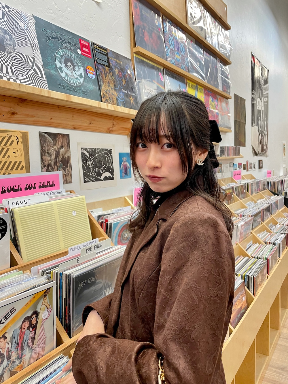 ブラウン系のハンドバッグ、ブラック系のスカート、ブラウン系のパンプスを着用したレディースの秋コーディネートの2枚目の写真