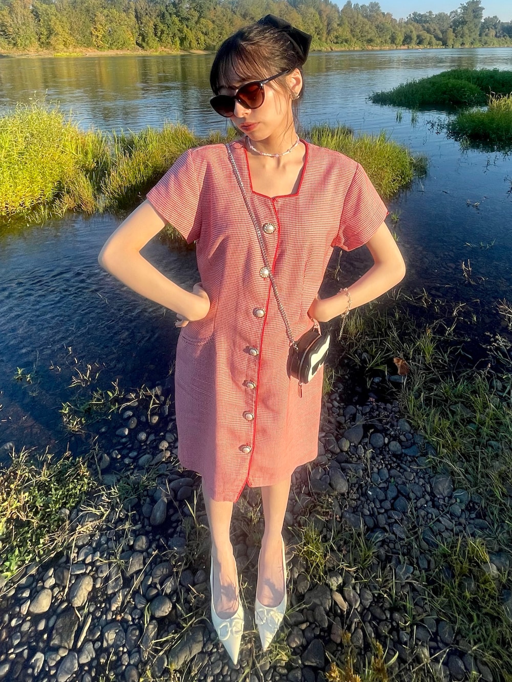 レッド系のワンピース、ブラック系のショルダーバッグ、ホワイト系のパンプスを着用したレディースの秋コーディネートの3枚目の写真