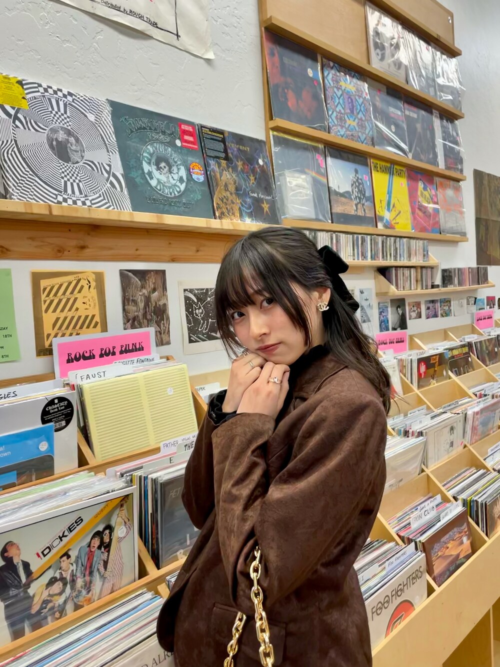 ブラウン系のハンドバッグ、ブラック系のスカート、ブラウン系のパンプスを着用したレディースの秋コーディネートの3枚目の写真