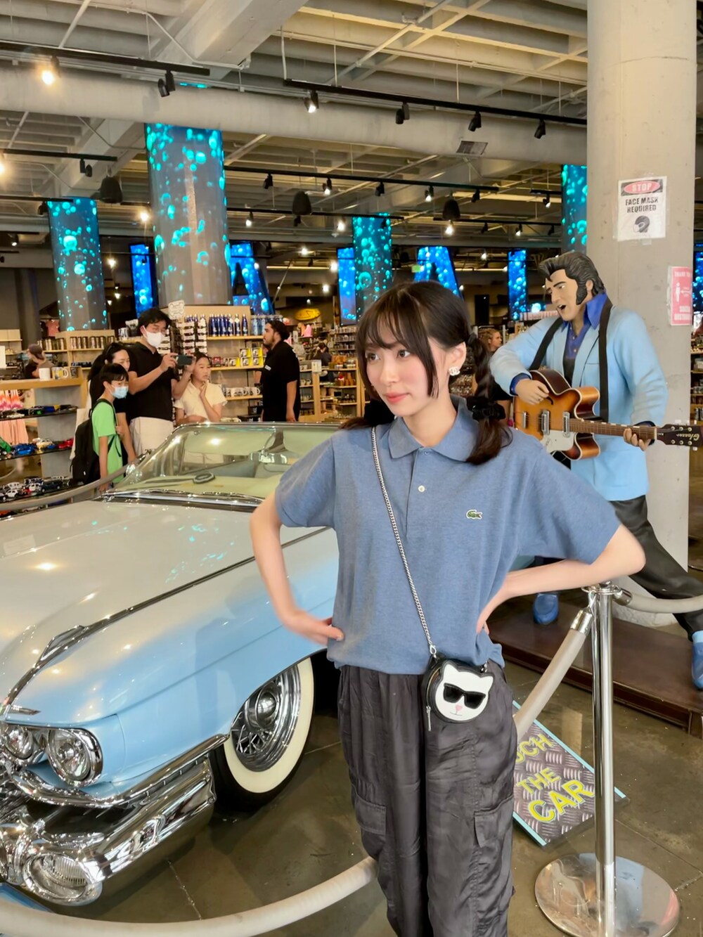 ブラック系のカーゴパンツ、ホワイト系のシューズ、ブルー系のポロシャツを着用したレディースの秋コーディネートの3枚目の写真