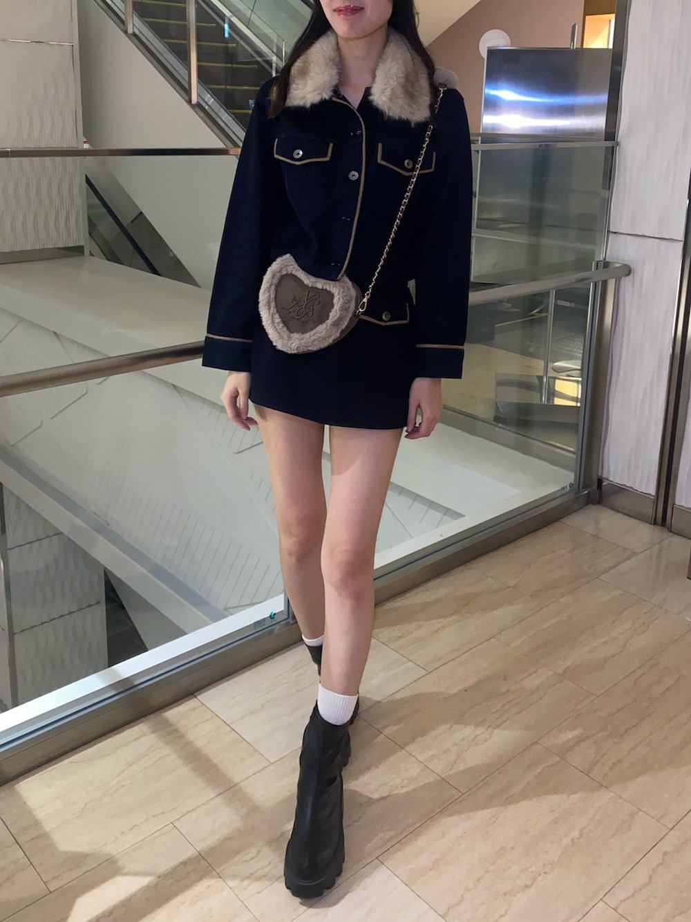 ブルー系のブルゾン、ブルー系のスカート、ブラウン系のショルダーバッグを着用したレディースの秋コーディネートの4枚目の写真