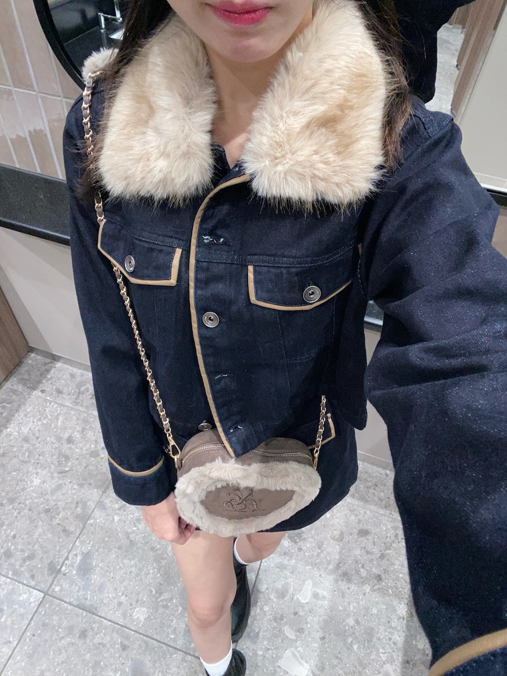 ブルー系のブルゾン、ブルー系のスカート、ブラウン系のショルダーバッグを着用したレディースの秋コーディネートの6枚目の写真