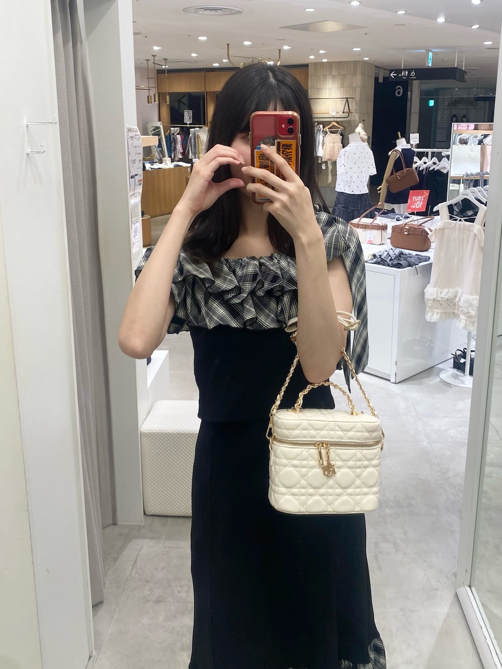 ブラック系のスカート、ホワイト系のショルダーバッグ、ベージュ系のサンダルを着用したレディースの秋コーディネートの4枚目の写真