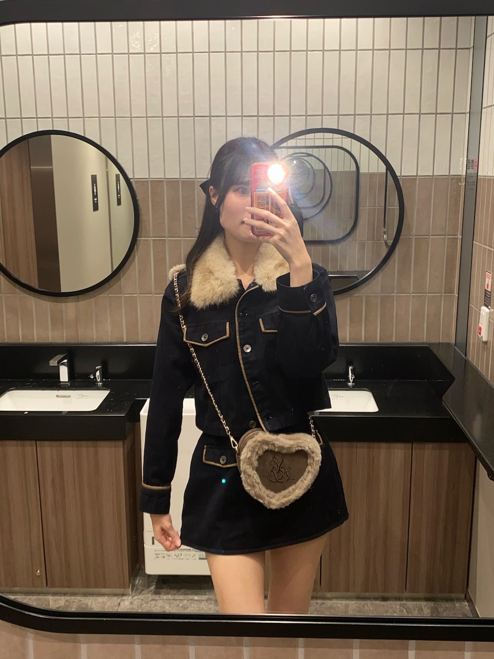 ブルー系のブルゾン、ブルー系のスカート、ブラウン系のショルダーバッグを着用したレディースの秋コーディネートの7枚目の写真