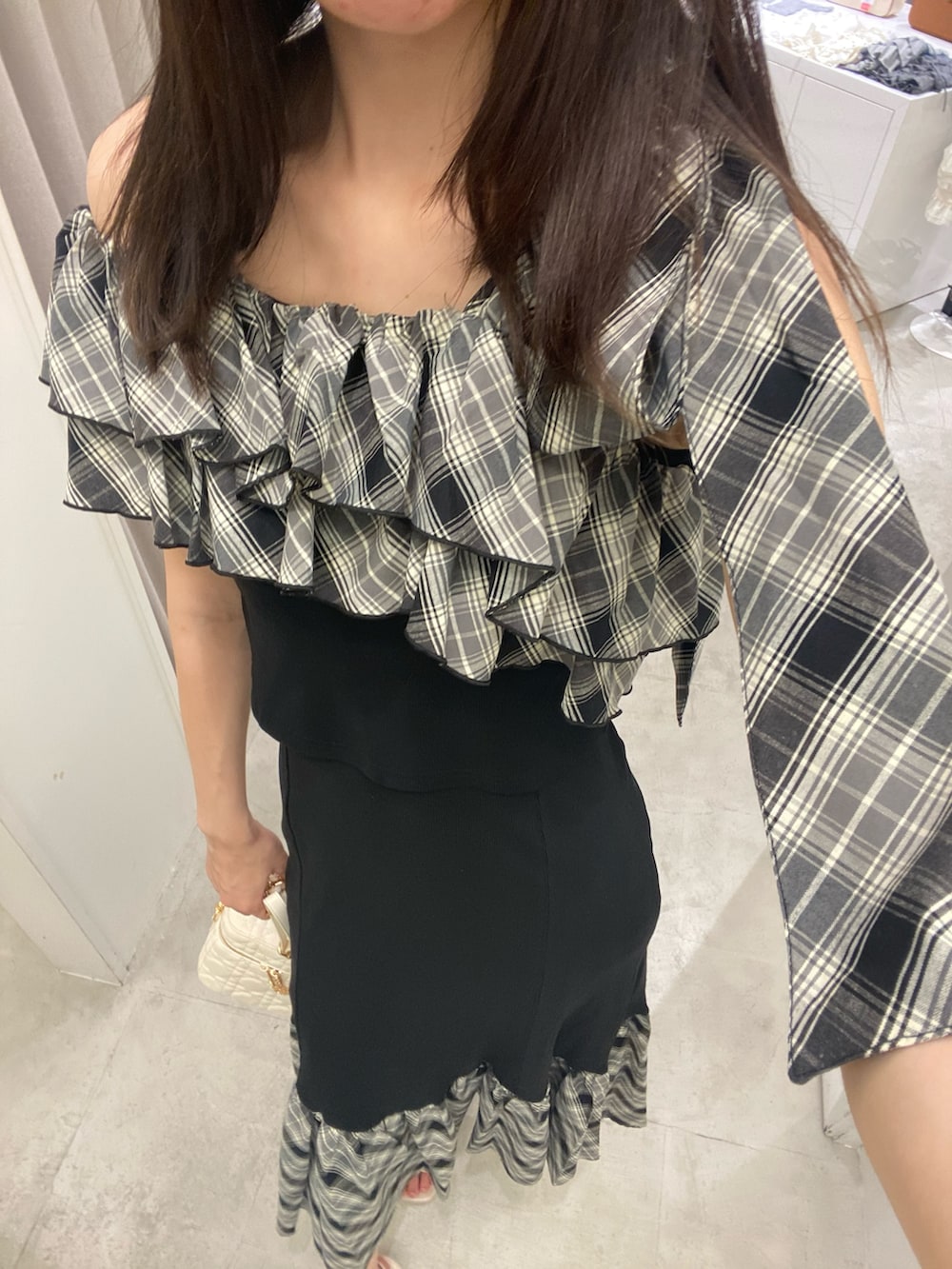 ブラック系のスカート、ホワイト系のショルダーバッグ、ベージュ系のサンダルを着用したレディースの秋コーディネートの6枚目の写真