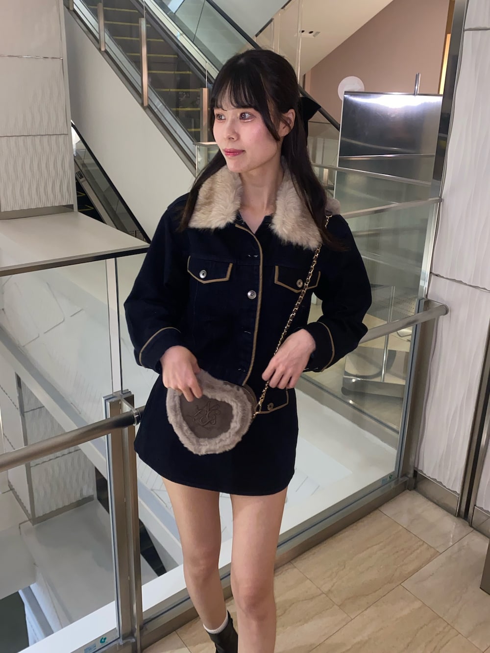 ブルー系のブルゾン、ブルー系のスカート、ブラウン系のショルダーバッグを着用したレディースの秋コーディネートの3枚目の写真