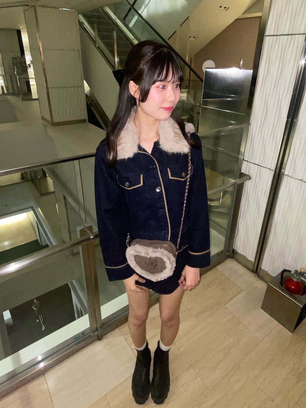 ブルー系のブルゾン、ブルー系のスカート、ブラウン系のショルダーバッグを着用したレディースの秋コーディネートの5枚目の写真