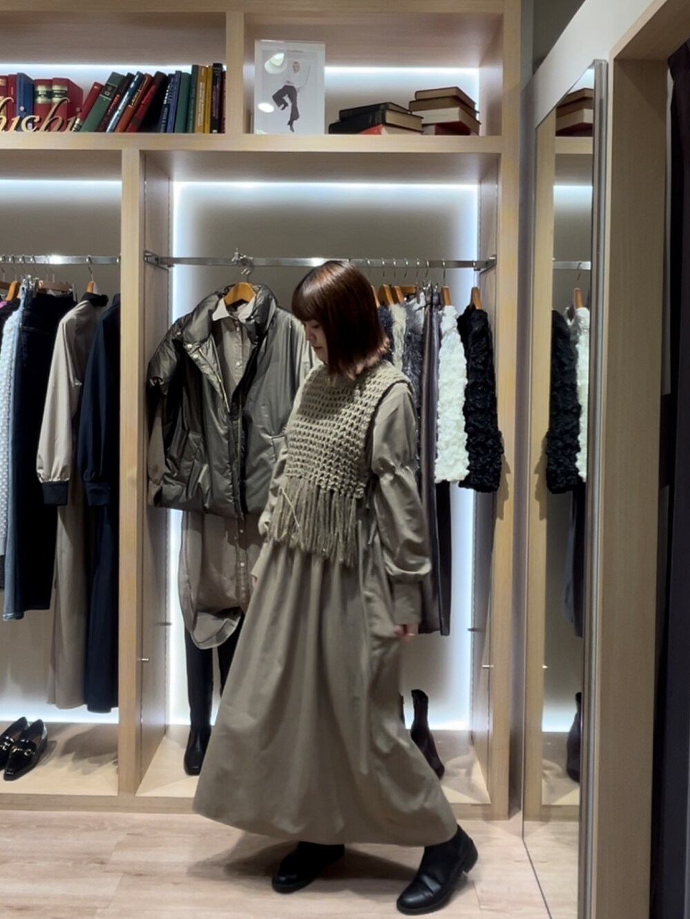 グリーン系のワンピース、ブラウン系のニット/セーターを着用したレディースの秋コーディネートの2枚目の写真