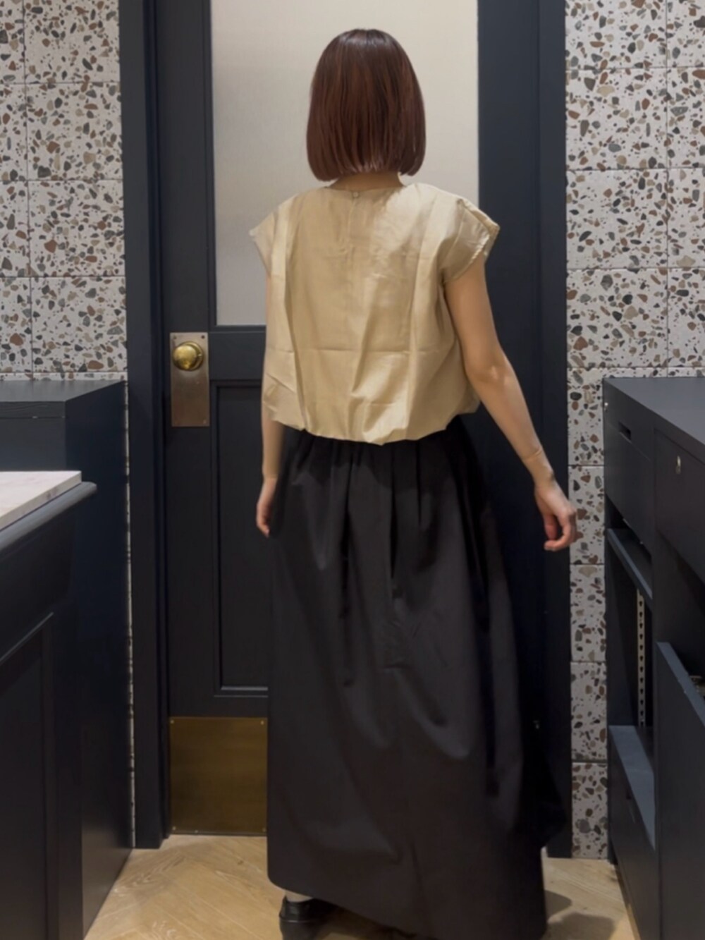 ベージュ系のシャツ/ブラウス、ブラック系のスカート、ブラック系のその他シューズを着用したレディースの春コーディネートの2枚目の写真