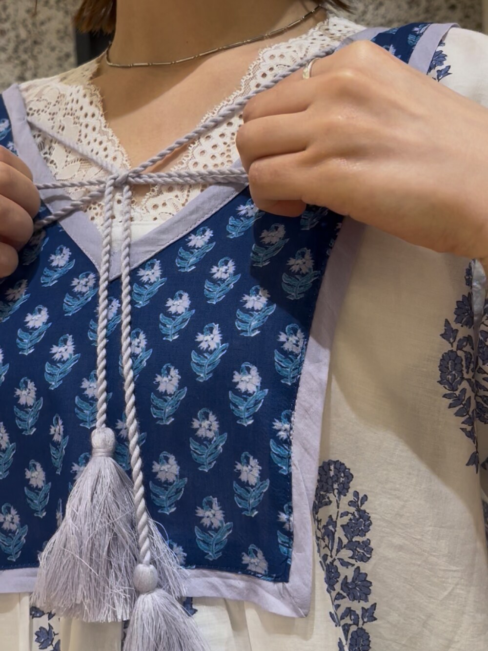 ホワイト系のワンピース、ホワイト系のタンクトップ、ベージュ系のハンドバッグを着用したレディースの春コーディネートの3枚目の写真