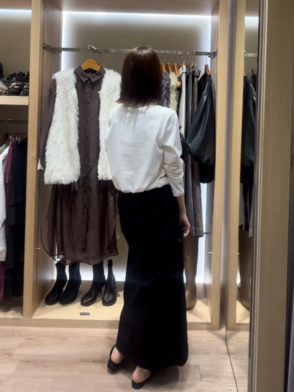 ホワイト系のTシャツ/カットソー、ブラック系のスカート、ブラック系のシューズを着用したレディースの秋コーディネートの2枚目の写真