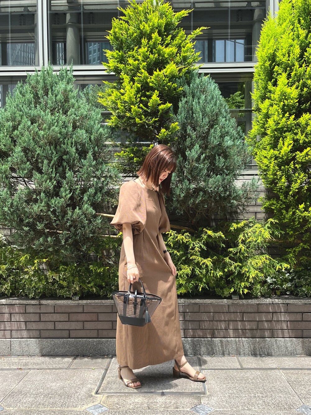 ブラウン系のワンピースを着用したレディースの春コーディネートの2枚目の写真