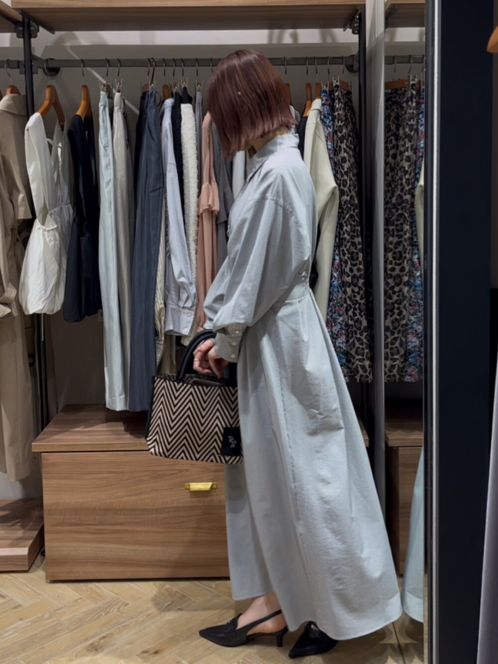 ブラック系のワンピース、ブラック系のハンドバッグ、ブラック系のパンプスを着用したレディースの春コーディネートの2枚目の写真