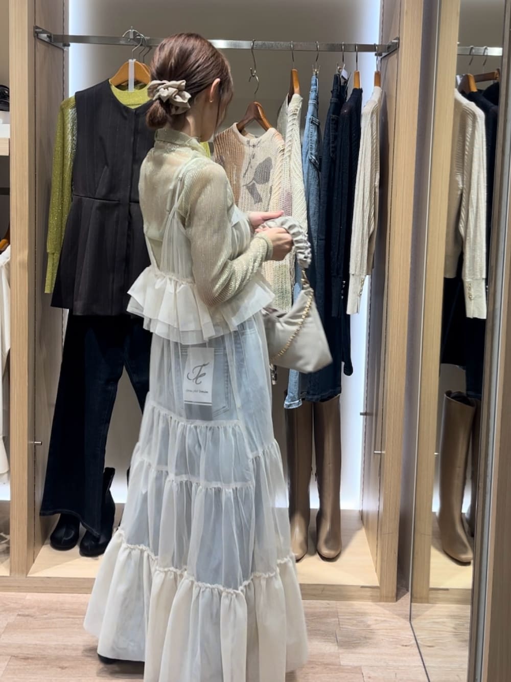 ゴールド系のTシャツ/カットソー、ホワイト系のワンピース/ドレス、ホワイト系のハンドバッグを着用したレディースの秋コーディネートの2枚目の写真