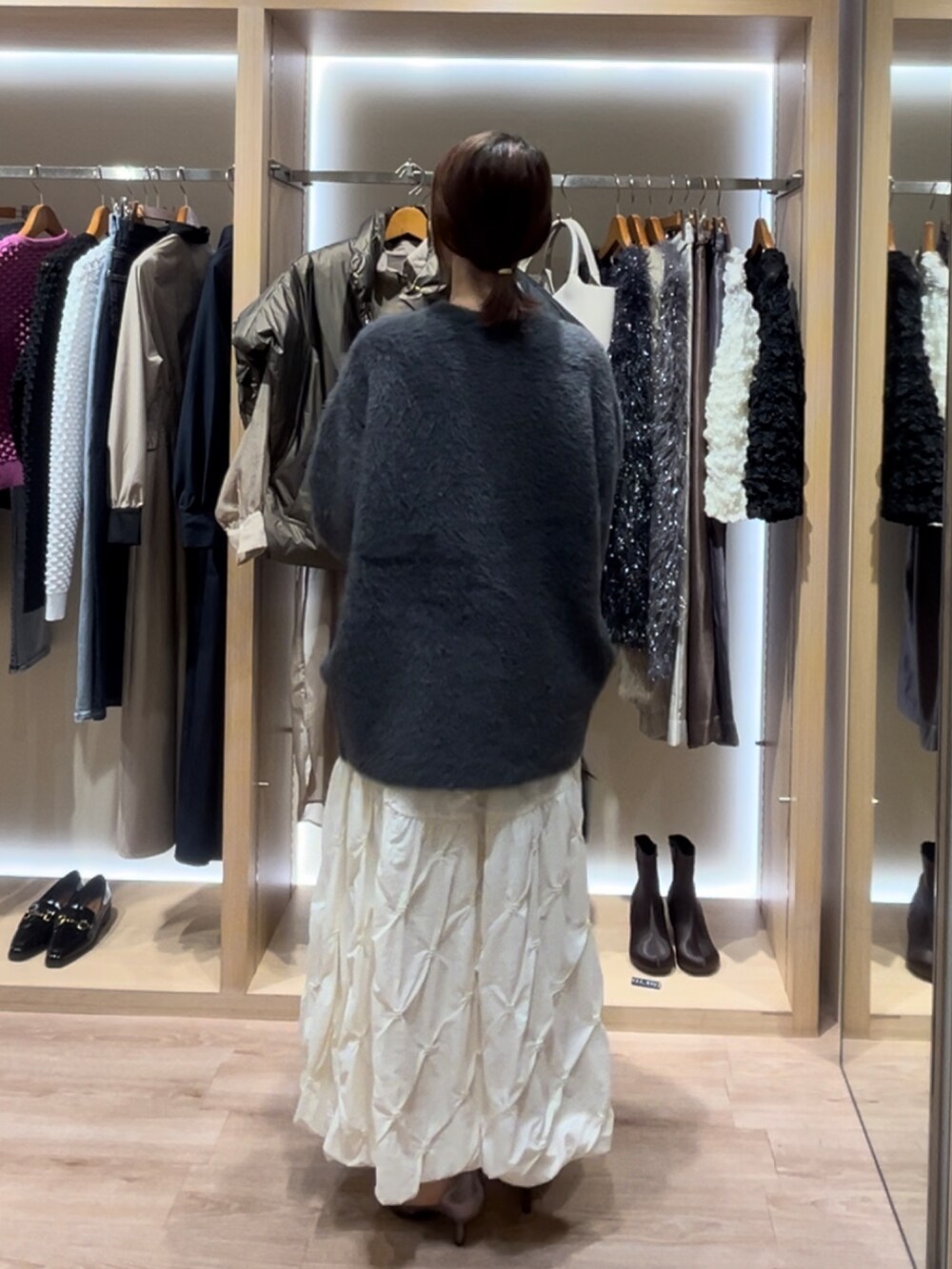 グレー系のカーディガン/ボレロ、ブラック系のスカート、ホワイト系のスカートを着用したレディースの秋コーディネートの4枚目の写真