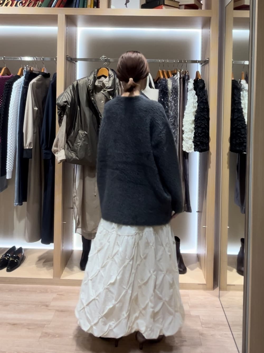 グレー系のカーディガン/ボレロ、ブラック系のスカート、ホワイト系のスカートを着用したレディースの秋コーディネートの3枚目の写真