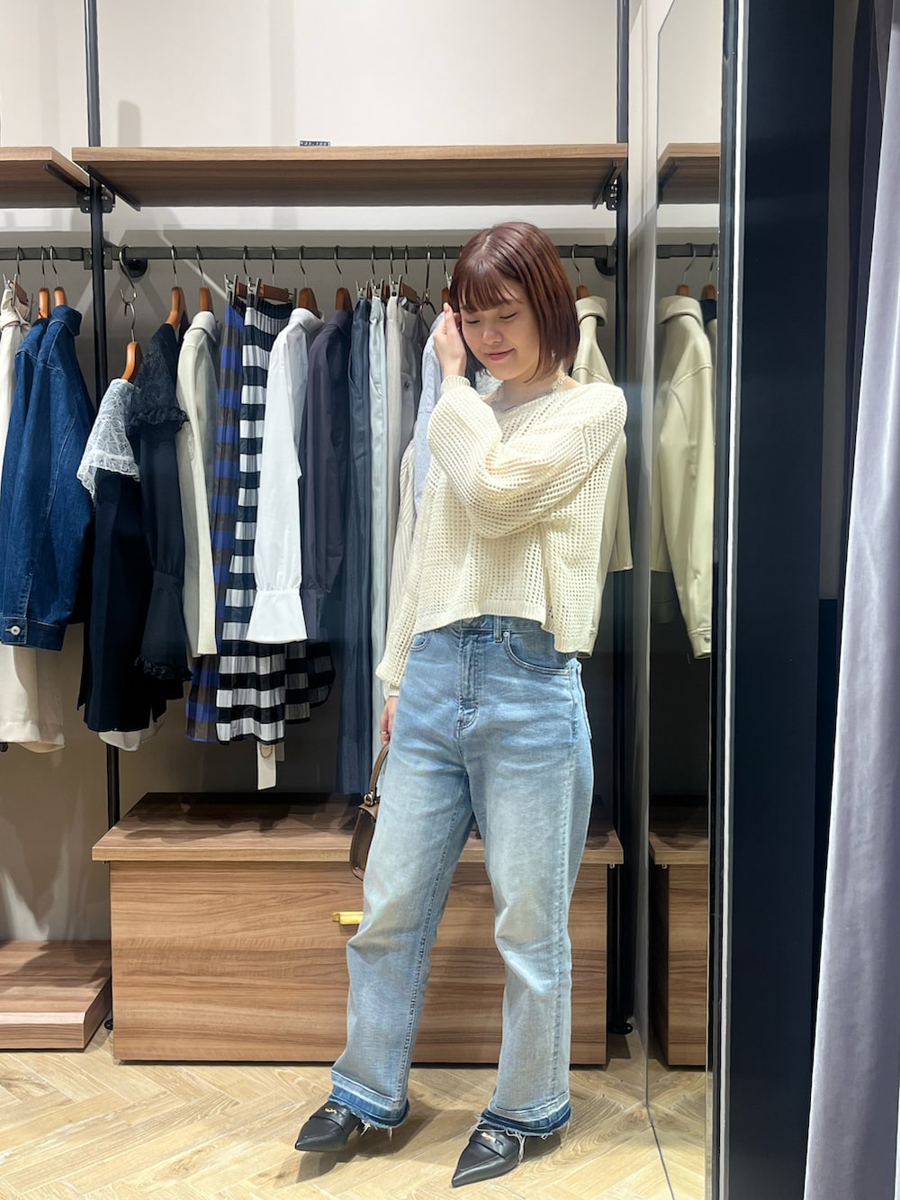 ホワイト系のニット/セーター、ブルー系のその他パンツ、ブラウン系のハンドバッグを着用したレディースの春コーディネートの2枚目の写真