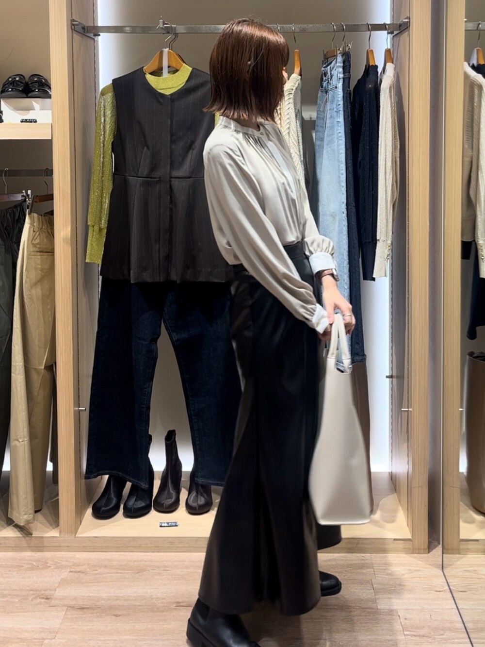 ベージュ系のシャツ/ブラウス、ホワイト系のハンドバッグ、ブラック系のその他パンツを着用したレディースの秋コーディネートの2枚目の写真