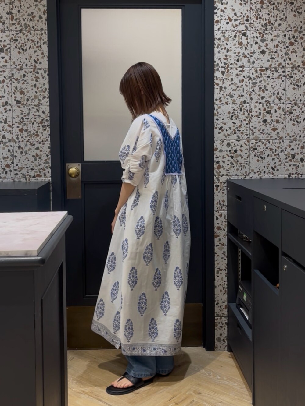 ホワイト系のワンピース、ホワイト系のタンクトップ、ベージュ系のハンドバッグを着用したレディースの春コーディネートの2枚目の写真