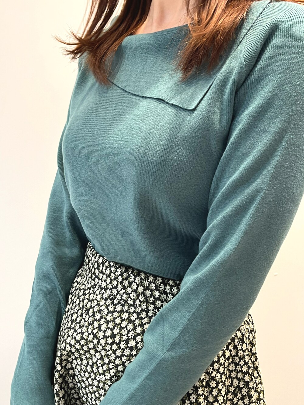 ブラック系のスカート、グリーン系のニット/セーター、ホワイト系のハットを着用したレディースの秋コーディネートの2枚目の写真