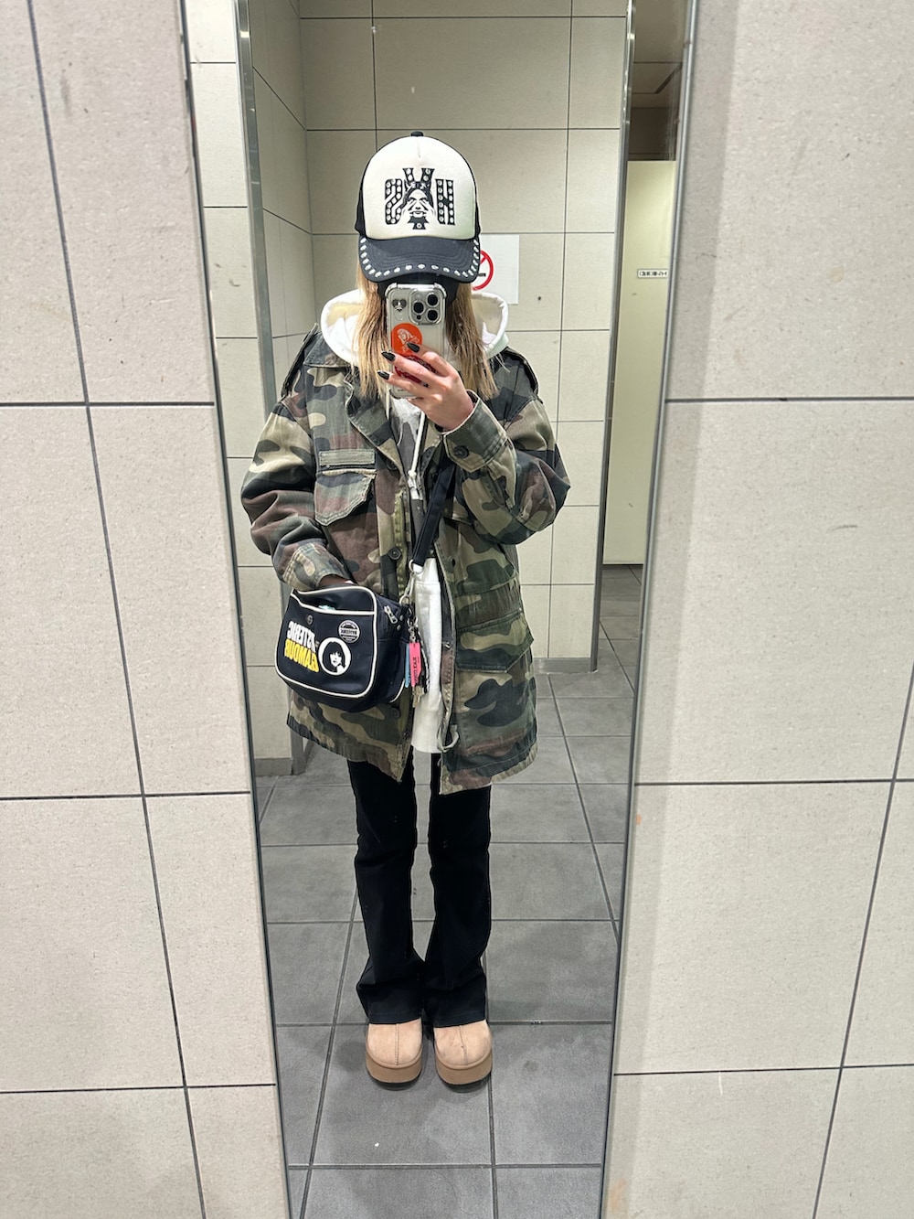 グリーン系のデニムジャケット、ブラック系のショルダーバッグ、ブラック系のパンツを着用したレディースの冬コーディネートの2枚目の写真