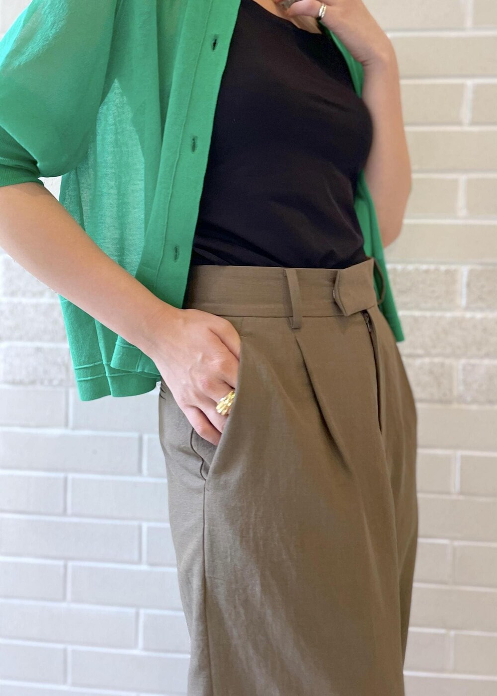 ブラウン系のその他パンツ、グリーン系のカーディガン/ボレロ、ブラック系のハットを着用したレディースの春コーディネートの7枚目の写真