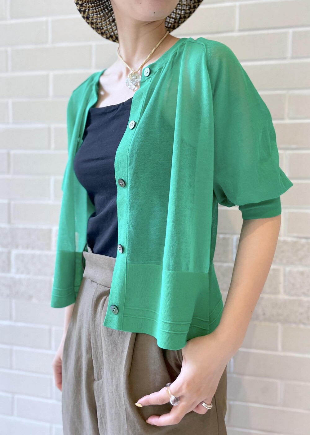 ブラウン系のその他パンツ、グリーン系のカーディガン/ボレロ、ブラック系のハットを着用したレディースの春コーディネートの5枚目の写真